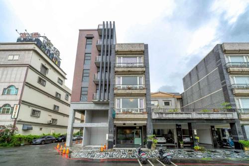 two tall buildings next to each other on a street at 花蓮發現民宿-無人民宿自助入住-包棟可烤肉可麻將 in Hualien City