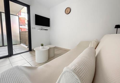 a white bedroom with a bed and a tv at Studio clim cosy avec piscine & terrasse in La Roquette-sur-Siagne
