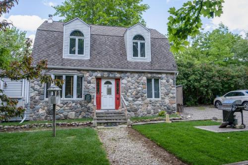 a stone house with a red door at 3 Bedroom 2 Bath Carriage House (Pet Friendly) in Bar Harbor
