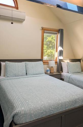 a bedroom with two beds and a window at 3 Bedroom 2 Bath Carriage House (Pet Friendly) in Bar Harbor