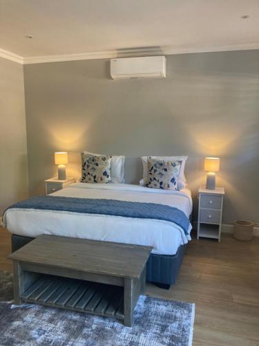 een slaapkamer met een bed met twee tafels en twee lampen bij Villa 121 Franschhoek Lermitage in Franschhoek