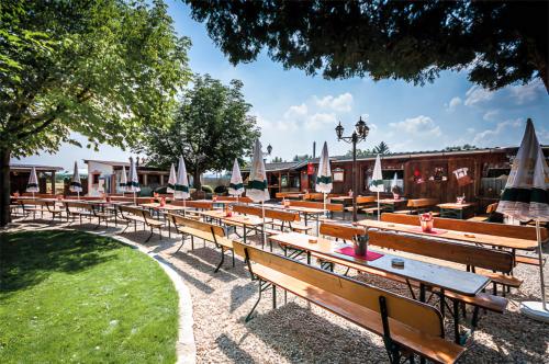 a row of tables and benches with umbrellas at Helles Wohlfühl Apartment in Landshut Altdorf in Altdorf
