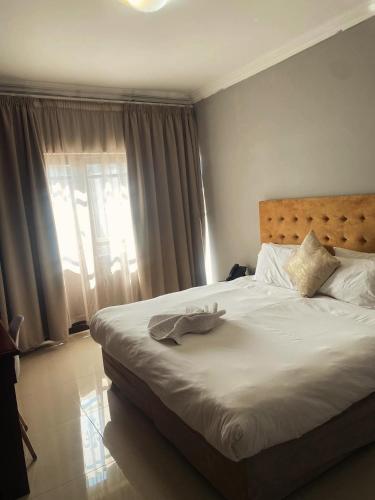 a bedroom with a large white bed with a window at Sapphire Hotel Halevy Heritage in Bloemfontein