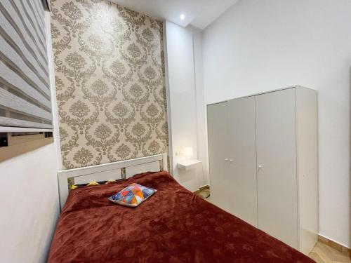 a small bedroom with a bed and a cabinet at Basim Filali in Kenitra