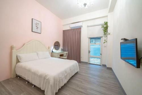 a bedroom with a bed and a flat screen tv at 花蓮發現民宿-無人民宿自助入住-包棟可烤肉可麻將 in Hualien City