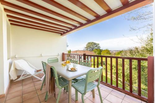 a patio with a table and chairs on a balcony at Résidence Pierre & Vacances La Villa Maldagora in Ciboure