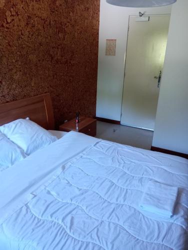 a bedroom with a white bed and a sliding door at Auberge le Chaudron in Montsapey