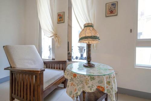 a table with a lamp and a chair in a room at 花蓮發現民宿-無人民宿自助入住-包棟可烤肉可麻將 in Hualien City