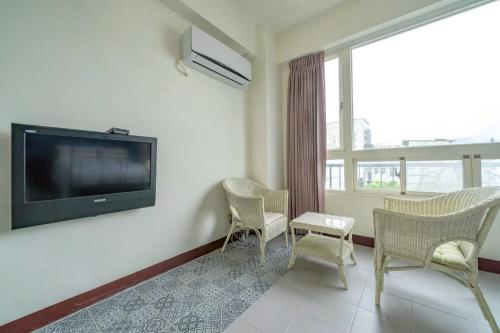 a living room with two chairs and a flat screen tv at 花蓮發現民宿-無人民宿自助入住-包棟可烤肉可麻將 in Hualien City