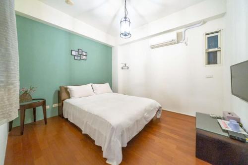 a bedroom with a bed and a table and a tv at 花蓮發現民宿-無人民宿自助入住-包棟可烤肉可麻將 in Hualien City