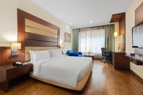 a large white bed in a hotel room at Country Inn & Suites by Radisson, Gurugram Sector 12 in Gurgaon
