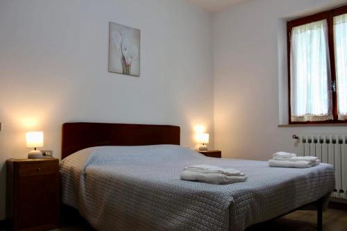 a bedroom with a bed with two towels on it at Appartamento Nando in Pian di Novello