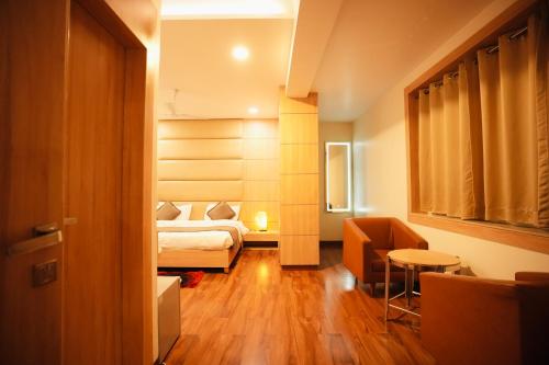 a hotel room with a bed and a chair at Hotel Pradeep Star Inn in Gorakhpur