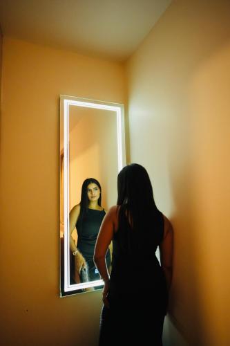 a woman standing in front of a mirror at Hotel Pradeep Star Inn in Gorakhpur