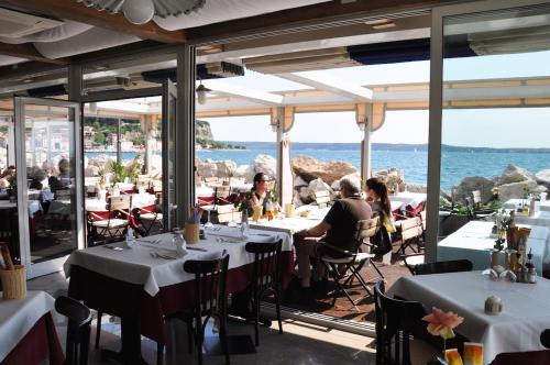 a group of people sitting at tables in a restaurant at Apartments & Rooms Riva in Piran