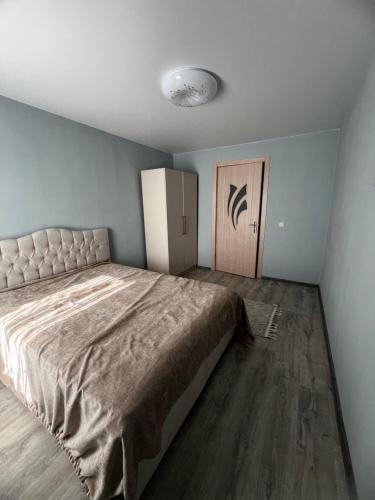 a bedroom with a large bed and a refrigerator at sky in Kutaisi