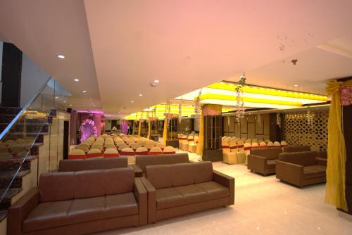 a theater with couches and chairs in a room at Hotel Pradeep Star Inn in Gorakhpur
