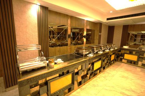 a kitchen with a long counter in a restaurant at Hotel Pradeep Star Inn in Gorakhpur