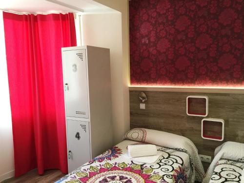 a small room with a bed and a red curtain at Mucho Madrid in Madrid