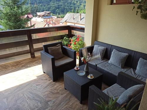 a patio with two chairs and a couch and a table at Skyline Villa in Azuga