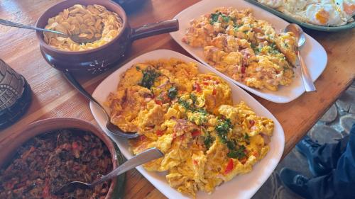 a table with three plates of food on a table at Cabana Vârful Ciucaș in Cheia