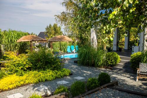 a resort with a pool and chairs and umbrellas at Villa Santorini in Konarzyny