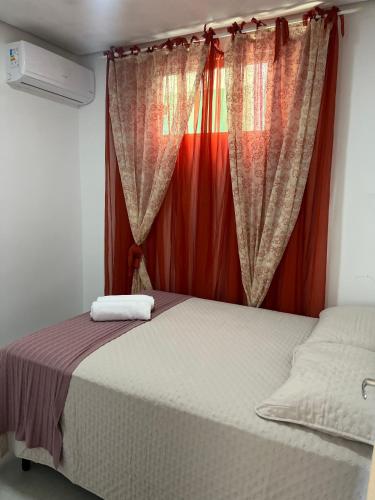 a bedroom with a bed and a window with curtains at Apartamento no Centro da Cidade in Parauapebas