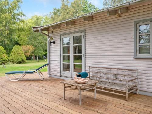 a bench on a deck next to a house at Holiday Home Åsemarie - 600m from the sea by Interhome in Dronningmølle