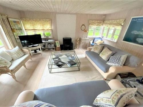 a living room with a couch and a table at Holiday Home Åsemarie - 600m from the sea by Interhome in Dronningmølle