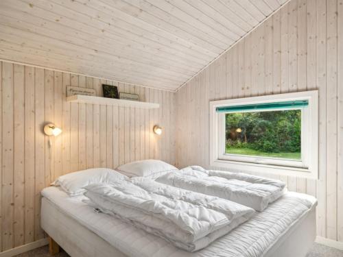 a white bed in a room with a window at Holiday Home Batsha - 350m from the sea by Interhome in Tisvildeleje