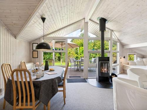a dining room with a table and a fireplace at Holiday Home Batsha - 350m from the sea by Interhome in Tisvildeleje
