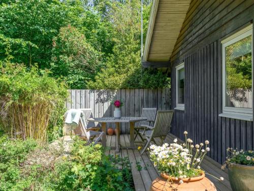 a patio with a table and chairs in a backyard at Holiday Home Naira - 1-8km from the sea by Interhome in Tisvildeleje