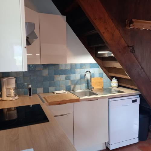 a kitchen with white cabinets and a sink at Maison de campagne 