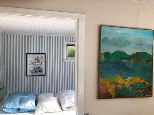 a painting hanging on a wall next to a bed at Holiday Home Eragon - 1-2km from the sea by Interhome in Gilleleje