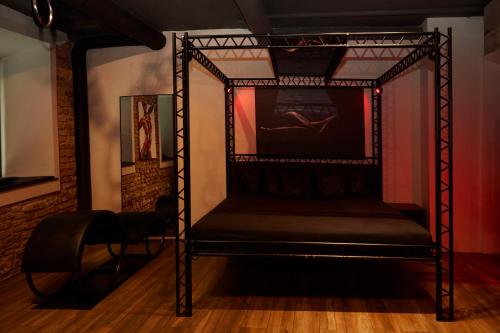 a black bed in a room with a wall at BDSM Black Apartments in Vilnius