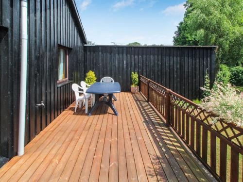 a wooden deck with a table and chairs on it at Holiday Home Elida - 300m from the sea by Interhome in Gilleleje
