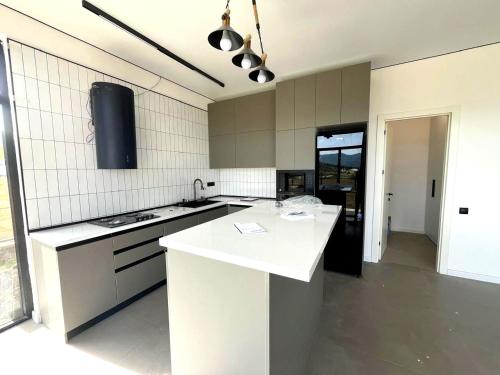 a white kitchen with a sink and a stove at Luxury Villa Agaraki with Pool in Tbilisi City