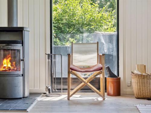 a chair sitting in front of a fireplace at Holiday Home Lasse - 1-5km from the sea by Interhome in Græsted