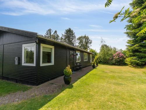 une petite maison noire avec une cour dans l'établissement Holiday Home Gritt - 800m from the sea by Interhome, à Gilleleje