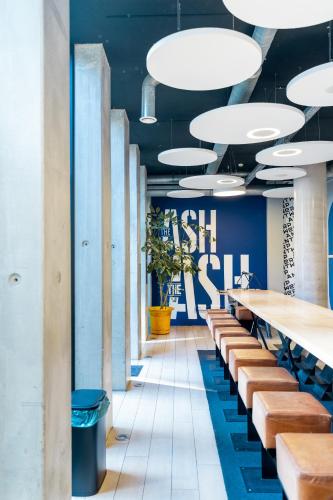a restaurant with blue walls and tables and benches at The ASH in Antwerp