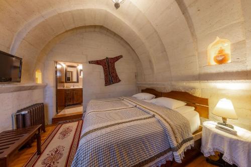 a bedroom with a bed and a cross on the wall at Cappadocia Cave Suites Adult Only in Goreme
