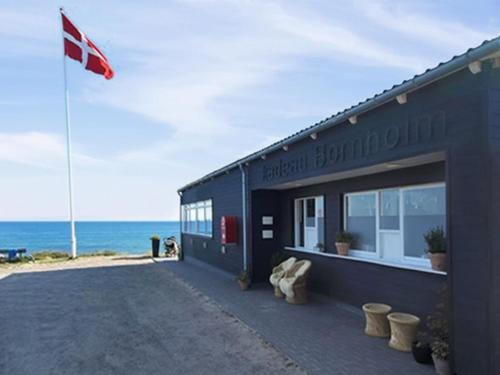 un edificio sulla spiaggia con una bandiera canadese di Apartment Benna - 120m from the sea by Interhome a Vester Sømarken