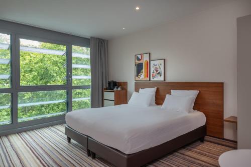 Una cama o camas en una habitación de Spark by Hilton Lyon Ouest