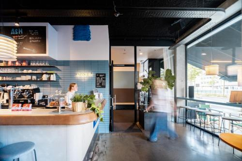 a person standing at a counter in a restaurant at The ASH in Antwerp