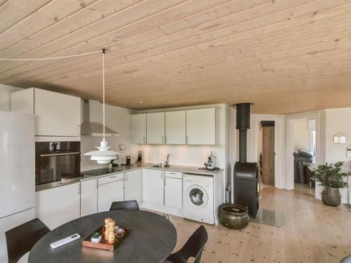 a kitchen with white cabinets and a table with chairs at Holiday Home Algeth - 350m from the sea by Interhome in Neksø
