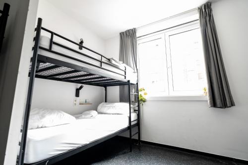 a bedroom with two bunk beds and a window at The ASH in Antwerp