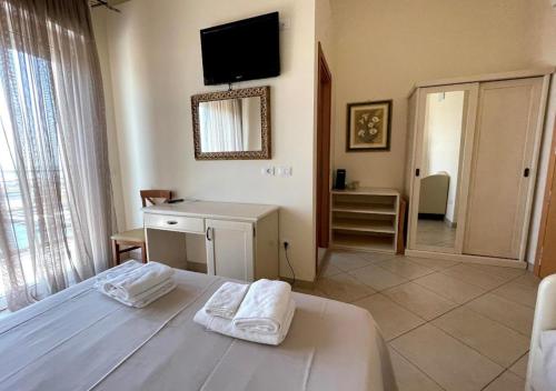 a bedroom with a bed and a tv on the wall at Hotel Franca in Milano Marittima
