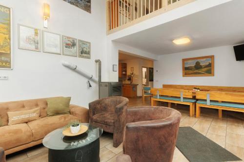 a living room with a couch and chairs and a table at Ferienhaus Eifel Atrium in Zweifelscheid