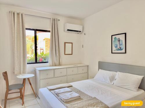 a bedroom with a bed and a chair and a window at Vila do Mar - Porto das Dunas in Aquiraz