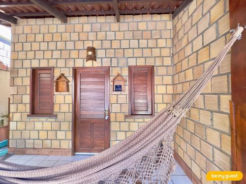 a hammock in front of a brick building at Casa Maresia em Flecheiras - 5 quartos e piscina in Curralinho